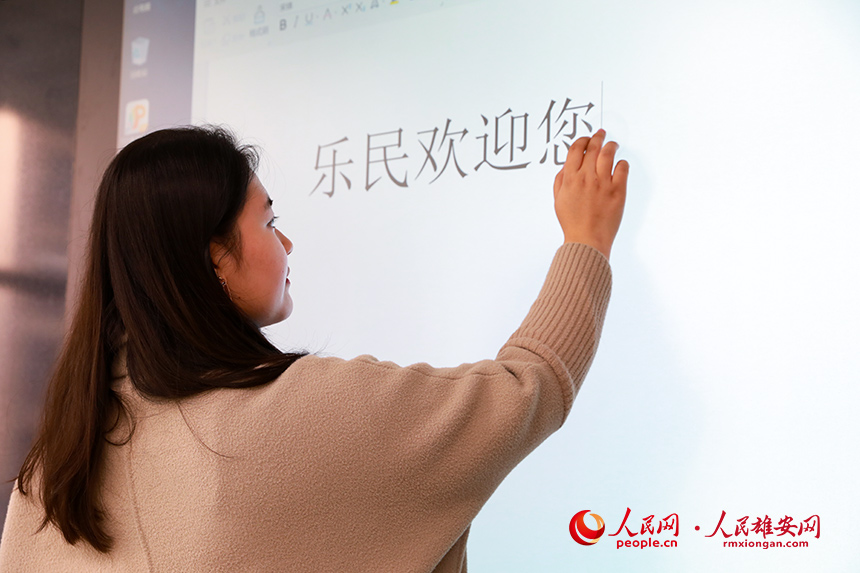 雄安容和樂民小學教室安裝有智慧黑板,既可作為普通黑板使用,又可作為電子屏幕。圖為學校老師正在使用智慧黑板打字。人民網 宋燁文攝