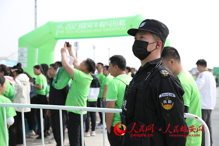 2023雄安半程馬拉松現(xiàn)場(chǎng)，堅(jiān)守崗位的安保人員。人民網(wǎng) 李兆民攝