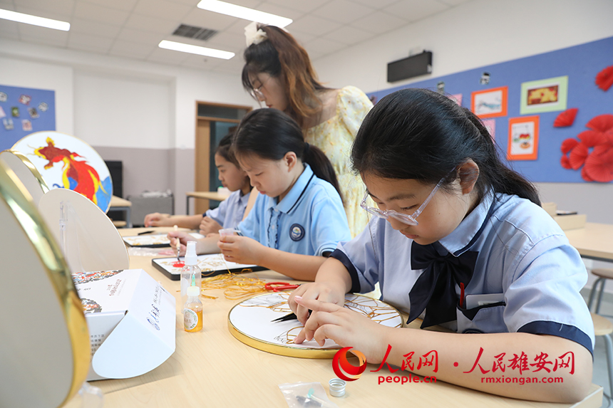 暑假期間，雄安容和樂民小學(xué)老師指導(dǎo)學(xué)生制作中國傳統(tǒng)工藝品——掐絲琺瑯畫，體驗(yàn)非遺藝術(shù)的制作流程。人民網(wǎng) 李兆民攝 (2)