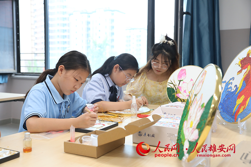 暑假期間，雄安容和樂民小學(xué)老師指導(dǎo)學(xué)生制作中國傳統(tǒng)工藝品——掐絲琺瑯畫，體驗(yàn)非遺藝術(shù)的制作流程。人民網(wǎng) 李兆民攝