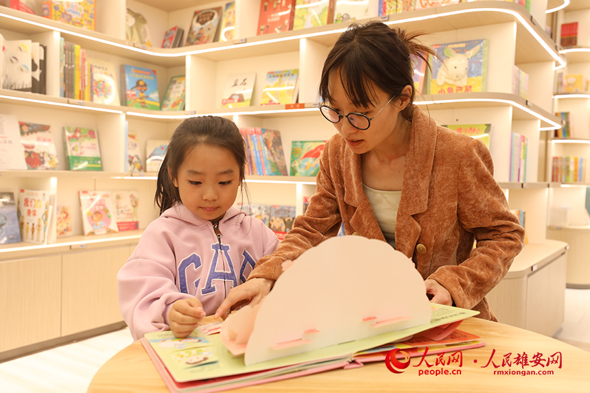 4月22日，在雄安新區新建片區的書店里，一名家長正在陪孩子閱讀。人民網記者 李兆民攝